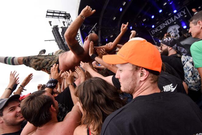 Pour étudier les mouvements de foule, un scientifique de l’INRIA (chapeau orange) danse au milieu des fans de heavy metal vêtu d’une combinaison équipée de capteurs pour collecter des données, lors d’un concert au Hellfest Summer Open Air Festival, à Clisson, le 26 juin 2022. 