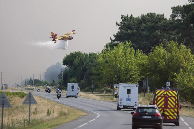 Un avion Canadair largue de l’eau le long de la route départementale 112 à La Teste-de-Buch, dans le sud-ouest de la France, le 14 juillet 2022.