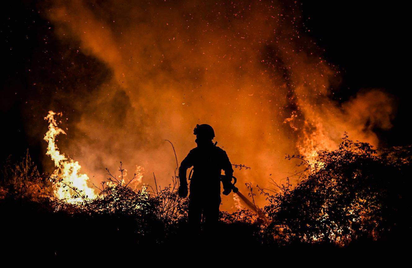 Ein Feuerwehrmann bekämpft am 15. Juli 2022 einen Waldbrand in der Nähe des Dorfes Erice, Portugal.
