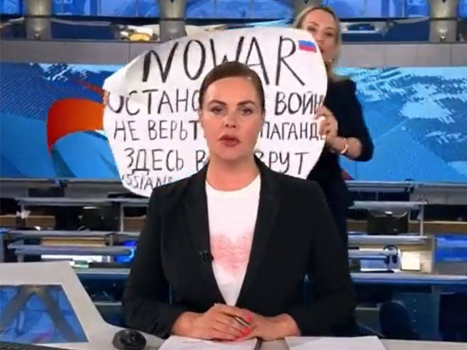 La periodista Marina Ovsiannikova, al fondo, durante su aparición en vivo en el noticiero televisivo del canal Pervi Kanal, el 14 de marzo de 2022.