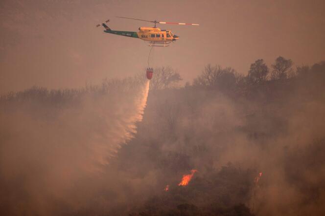 Un hélicoptère largue de l’eau sur un feu de forêt dans la chaîne de montagnes Sierra de Mijas, dans la province de Malaga, le 15 juillet 2022.