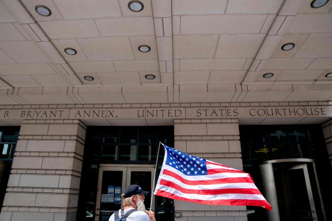 Un activista republicano sostiene una bandera estadounidense frente al Tribunal de Distrito el primer día de la selección del jurado en el juicio del ex estratega de la Casa Blanca Steve Bannon en Washington el 18 de julio de 2022.