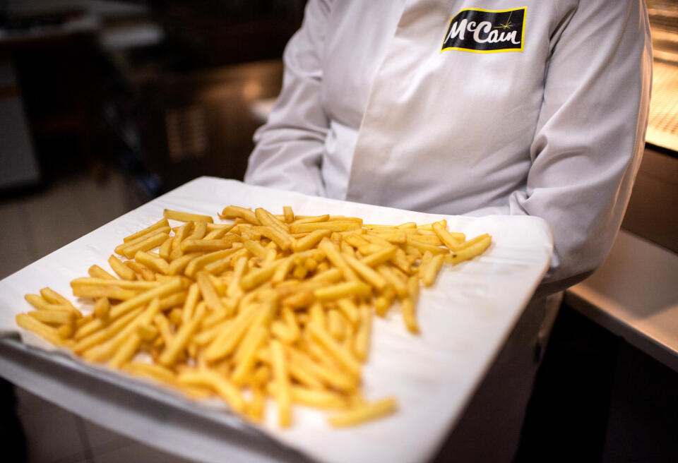 An employee holds a plate of French fries at the McCain French fries factory in Matougues on May 17, 2019. (Photo by Martin BUREAU / AFP)