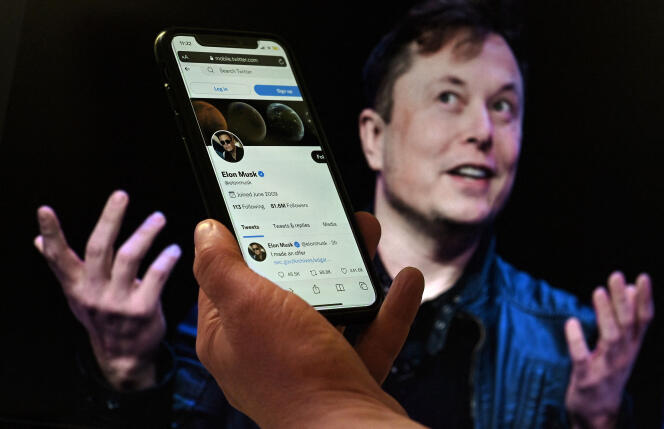 A phone screen shows Elon Musk's Twitter account, with a photo of him in the background, on April 14, 2022, in Washington, USA. 