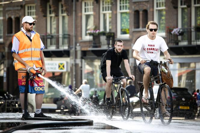 Un empleado municipal riega el suelo en el centro de Ámsterdam el 19 de julio de 2022.
