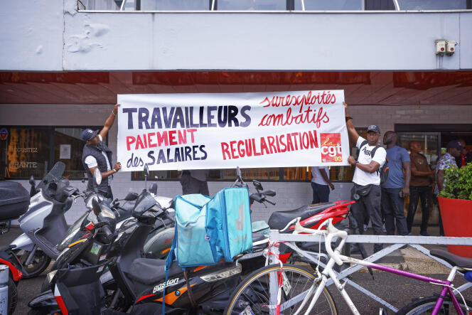 A l'entrée de l'hôtel Ibis à Bagnolet (Seine-Saint-Denis), converti en centre d'hébergement d'urgence depuis le début de la crise sanitaire, les employés sans-papiers lancent un mouvement de grève pour exiger le paiement de leurs salaires et leur régularisation, le 20 juillet 2022.