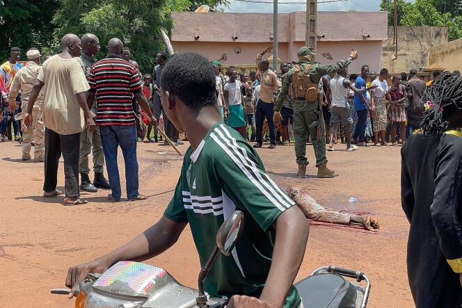 Un homme soupçonné d’avoir participé à une attaque terroriste déjouée est au sol, après avoir été battu par la foule, devant la base militaire de Kati, au Mali, le 22 juillet 2022.