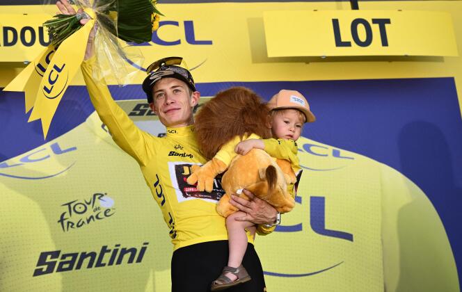 Jumbo-Visma holds his daughter Frida as he celebrates with the overall leader's yellow jersey on the podium after the 20th stage of the Tour de France on July 23, 2022.