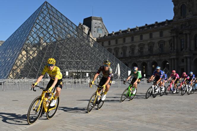 The peloton rides by the iconic Louvre Pyramid, in Paris.