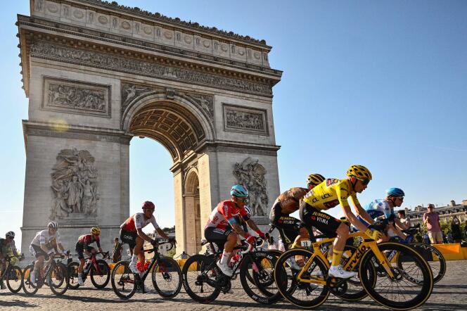 The peloton rides past the Arc de Triomphe, in Paris. 