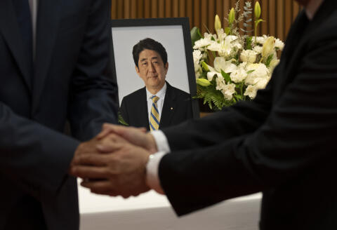 Japanese Ambassador to Canada Kanji Yamanouchi shakes hands with Prime Minister Justin Trudeau after Trudeau signed a book of condolences for former Japanese Prime Minister Shinzo Abe at the Japanese embassy, Tuesday, July 12, 2022, in Ottawa, Ontario. Abe was fatally shot last week in western Japan while giving a campaign speech. (Adrian Wyld/The Canadian Press via AP)