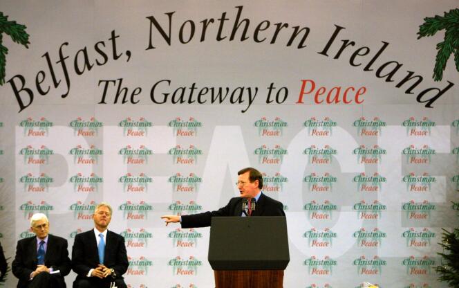 In this file photo taken on December 13, 2000 Northern Ireland First Minister David Trimble gestures to U.S President Bill Clinton while Northern Ireland Deputy First Minister Seamus Mallon looks on during the speeches in the Odyssey Arena in Belfast.