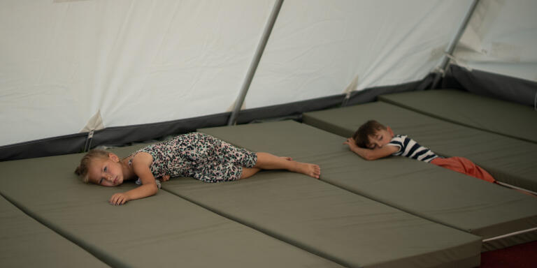 Des jeunes enfants déplacés dans l'une des tentes du centre de réfugiés de la ville acceuillant majoritairement des déplacés venus de l'est de l'Ukraine. Lviv, Ukraine, le 23 juillet 2022.