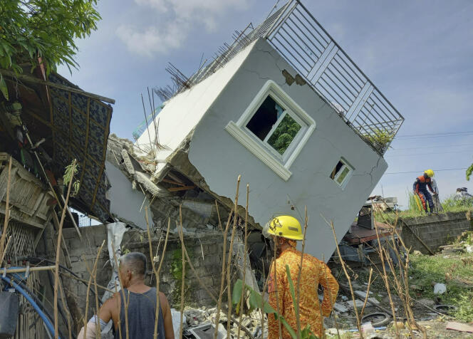 Rescuers check on a damaged house