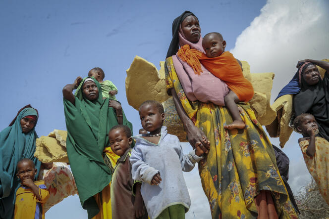 Des femmes somaliennes et leurs enfants, fuyant les zones du pays touchées par la sécheresse, arrivent dans un camp de fortune pour les réfugiés situé en banlieue de Mogadiscio, le 30 juin 2022. 