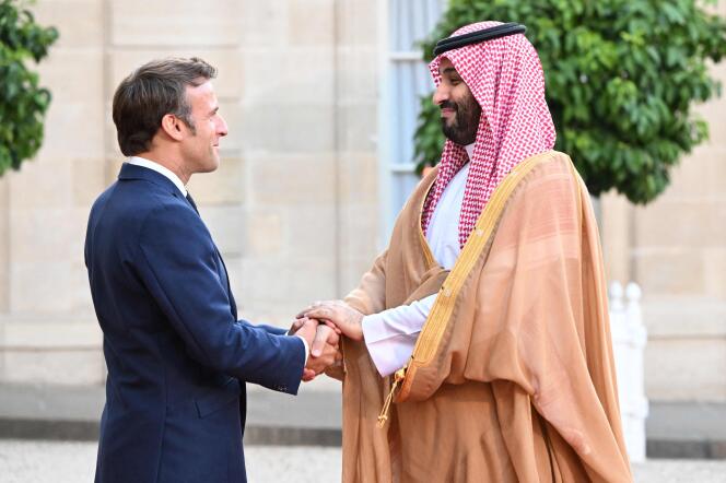 Emmanuel Macron welcomes Mohammed bin Salman with a long handshake at the Elysee on July 28, 2022.