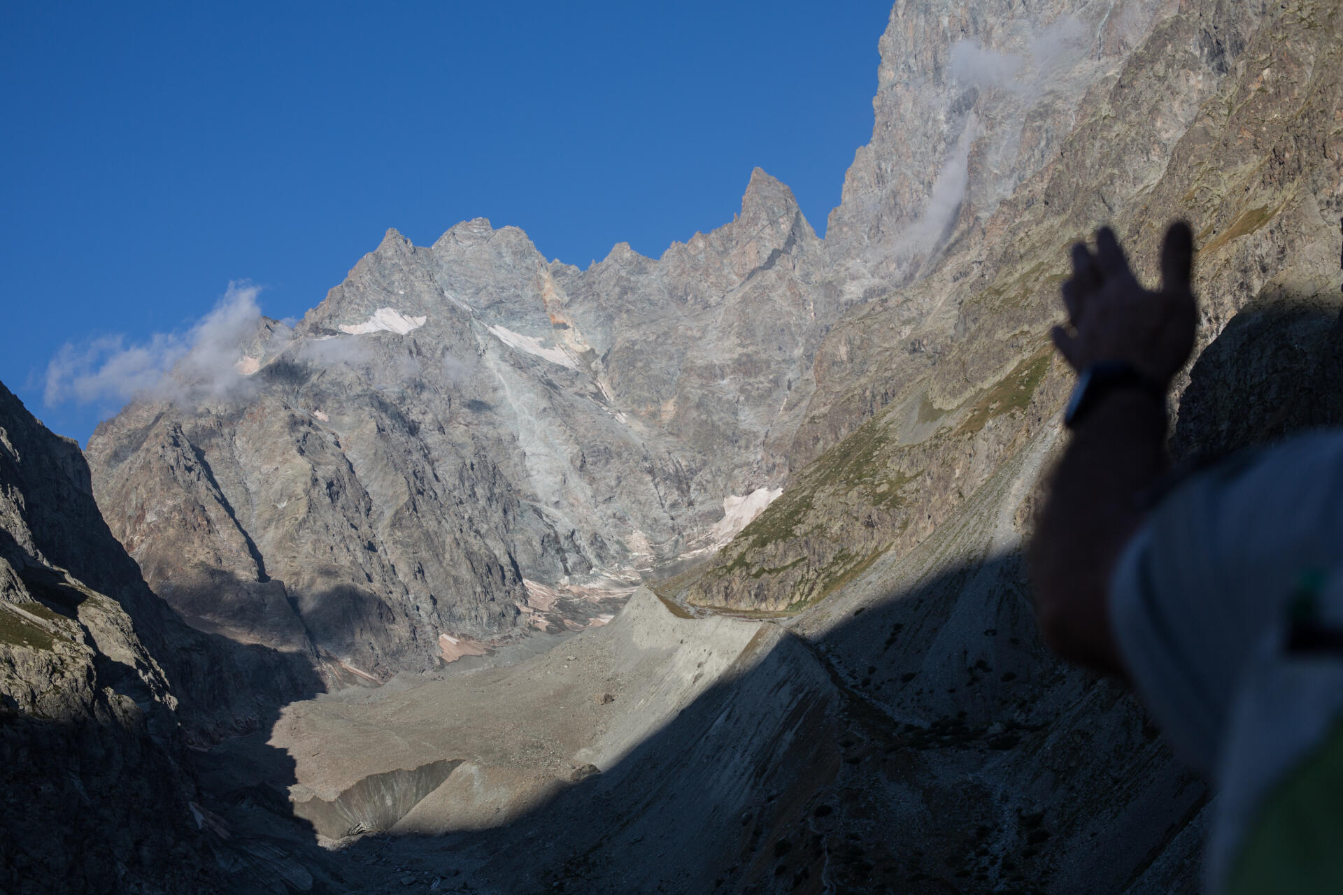 Thierry Maillet, technicien patrimoine au parc national des Ecrins, sur le secteur de Vallouise, montre le glacier Noir, dont une partie est recouverte par des cailloux, dans les Hautes-Alpes, le 26 juillet 2022.
