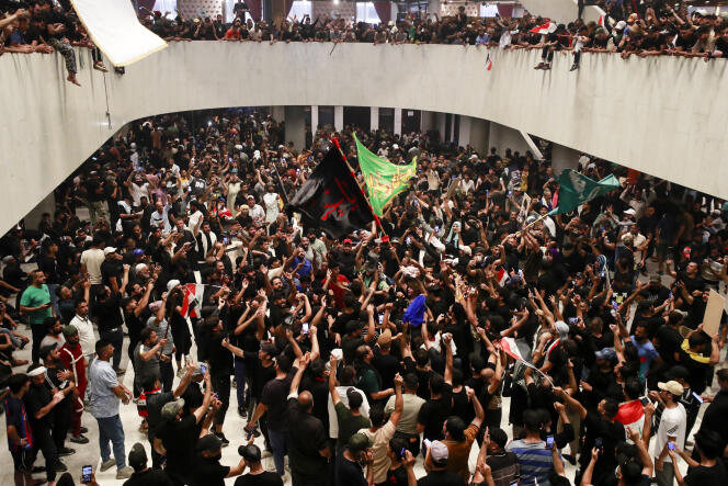 Des partisans de Moqtada Al-Sadr applaudissent après avoir pénétré dans le bâtiment du Parlement irakien, situé dans la zone verte de haute sécurité de la capitale, Bagdad, le 30 juillet 2022. 