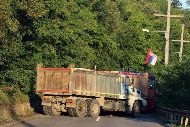 Un drapeau serbe est vu alors que des camions bloquent une route à Zupce, au Kosovo, le 1er août 2022.