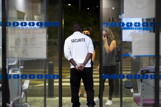 A security guard invites people to call 15 (SAMU, emergency medical services) in front of the ER of the hospital complex in La Roche-sur-Yon, July 30, 2022.