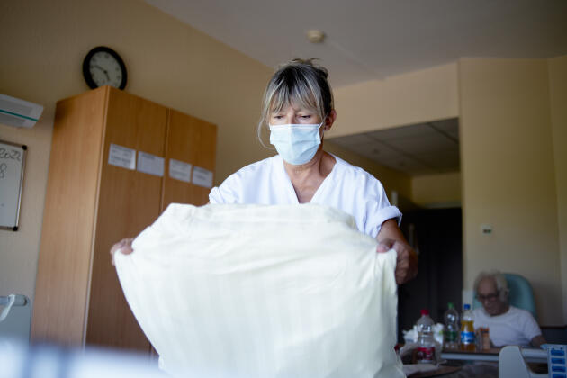 Nathalie, 59, nursing assistant at the geriatrics center of the GHR in Mulhouse and South-Alsace, makes a resident's bed on July 18, 2022. She has worked in the service for fifteen years.