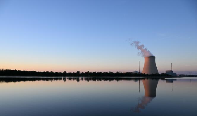 The Isar Nuclear Power Plant with its cooling tower reflects in the river Isar in Essenbach near Landshut, southern Germany, on August 3, 2022.