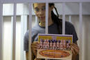 WNBA star and two-time Olympic gold medalist Brittney Griner holds images standing in a cage at a courtroom for a hearing in Khimki just outside Moscow, Russia, Thursday, Aug. 4, 2022. Closing arguments in Brittney Griner's cannabis possession case are set for Thursday, nearly six months after the American basketball star was arrested at a Moscow airport in a case that reached the highest levels of US-Russia diplomacy. (Evgenia Novozhenina/Pool Photo via AP)
