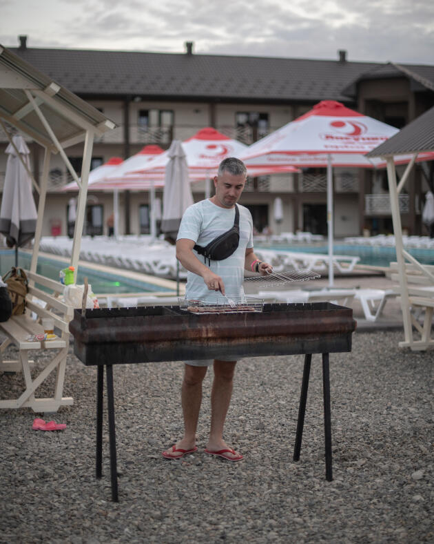 Siergiej Szumaczenko przygotowuje obiad dla swojej rodziny w hotelu w Sołotwinie na Ukrainie, 26 lipca 2022 r.