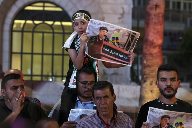 Palestinians hold placards depicting Islamic Jihad commander Taiseer al-Jabari, killed in an Israeli air strike on August 5