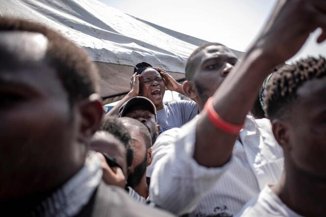 Une jeune femme pleure la mort de son frère tandis que les cercueils des militants, tués lors des manifestations à Goma réclamant le départ de la Monusco, passent à Goma, en République démocratique du Congo, le 5 août 2022.
