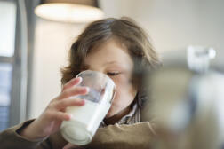 Gros plan d’un garçon buvant un verre de lait.