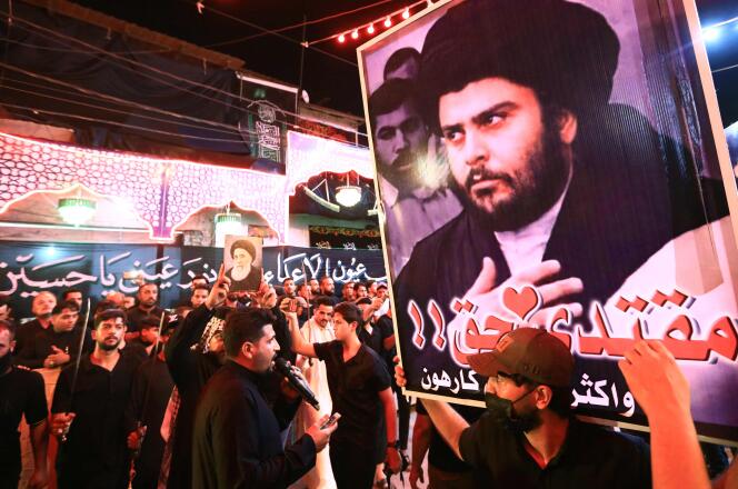 Des musulmans chiites brandissent un portrait de Moqtada Al-Sadr à Nasiriyah, dans le sud de l’Irak, le 5 août 2022.