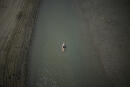 A paddle boarder passes through a drying portion of the Verdon Gorge in southern France, Tuesday, Aug. 9, 2022. France was in the midst of its fourth heat wave of the year Monday as the country faces what the government warned is its worst drought on record. (AP Photo/Daniel Cole)
