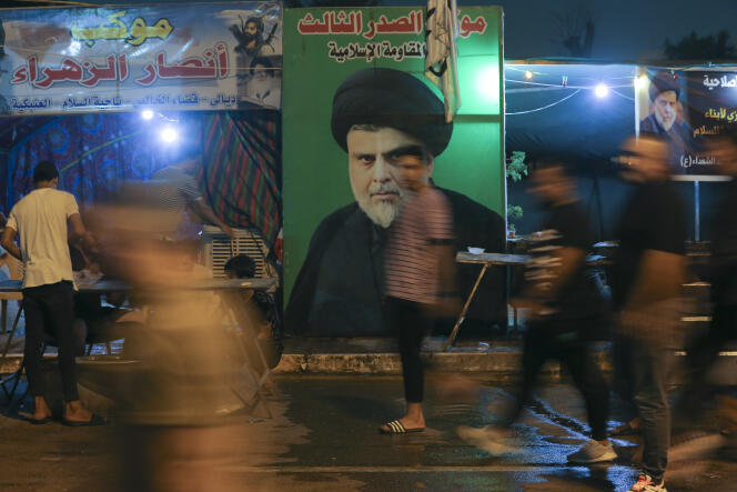 Des partisans de Moqtada Al-Sadr passent devant son portrait, face au Parlement irakien, à Bagdad, le 6 août 2022. 