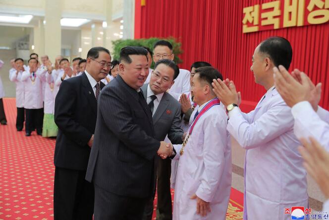 Cette photo du 10 août 2022, publiée par l’Agence centrale de presse coréenne, montre le dirigeant nord-coréen Kim Jong-un saluant des responsables du département de la santé et des scientifiques à Pyongyang.