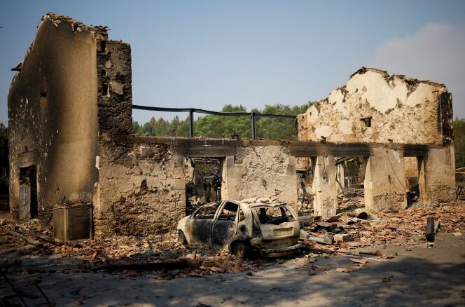 Une maison et une voiture détruites par le feu, à Belin-Béliet (Gironde), alors que les feux de forêt continuent de se propager dans la région, le 11 août 2022. 