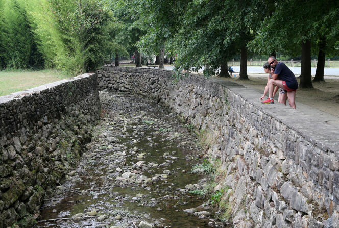 Deux personnes observent la rivière Galardi asséchée, à Ascain (Pyrénées-Atlantiques), le 12 juillet 2022. 