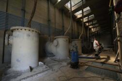 Un travailleur déplace un tube à l’intérieur d’une pompe d’assèchement à Boretto (Italie), sur le fleuve Pô, le 15 juin 2022.