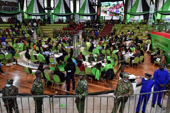 I soldati mantengono un cordone di sicurezza attorno agli impiegati della commissione elettorale che controllano i risultati delle elezioni presidenziali appena concluse, a Nairobi il 14 agosto 2022.