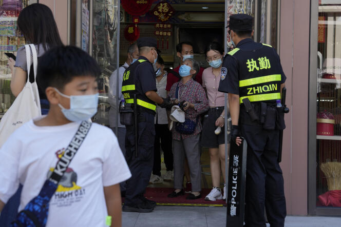Members of the security forces at the entrance of a store in Beijing, August 16, 2022.  