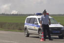 In this image taken from video provided by the RU-RTR Russian television on Tuesday, Aug. 16, 2022, a policeman blocks a way to the site of explosion at an ammunition storage of Russian army near the village of Mayskoye, Crimea. Explosions and fires ripped through an ammunition depot in Russian-occupied Crimea on Tuesday in the second suspected Ukrainian attack on the peninsula in just over a week, forcing the evacuation of more than 3,000 people. (RU-RTR Russian Television via AP) RUSSIA OUT