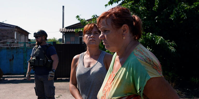 Des tirs d'artillerie fusent dans le ciel de chaque côté, une dame regarde au loin, inquiète. Elle vit dans le village de Zaitseve, situé pile entre les positions russes et ukrainiennes. Le 29 juillet 2022 à Zaitseve.