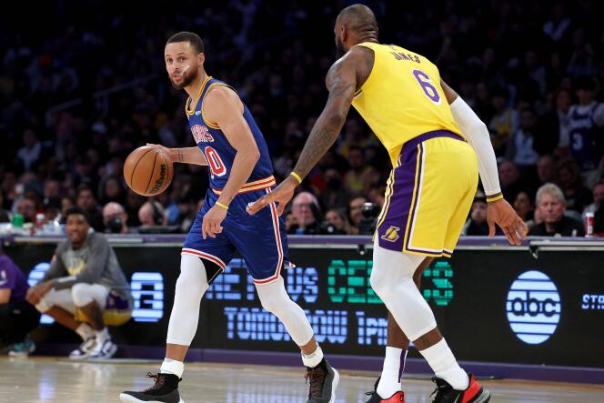 Stephen Curry (blue jersey), defending champion with the Golden State Warriors, against Los Angeles Lakers player LeBon James, in Los Angeles, March 6, 2022. 