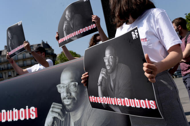 Protesters hold up signs calling for the release of Olivier Dubois on June 8, 2021, during a rally in support of the journalist kidnapped in Mali.