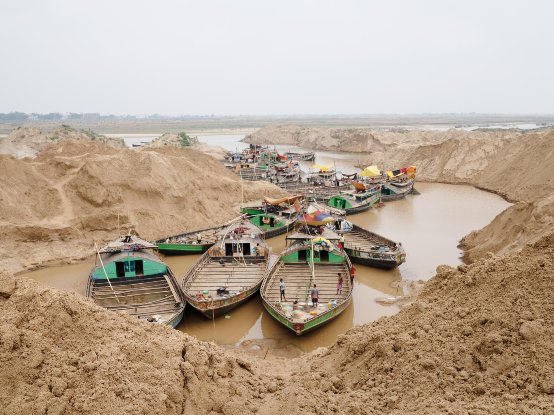 Le barche parcheggiano per diversi chilometri lungo le rive del Son, nello stato del Bihar (India), e presto saranno riempite di questa sabbia, il 23 giugno 2022.