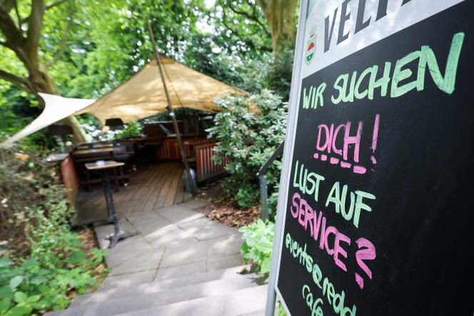 A poster at the entrance to a restaurant in Hamburg (Germany) indicates that it is looking for staff, July 6, 2022.