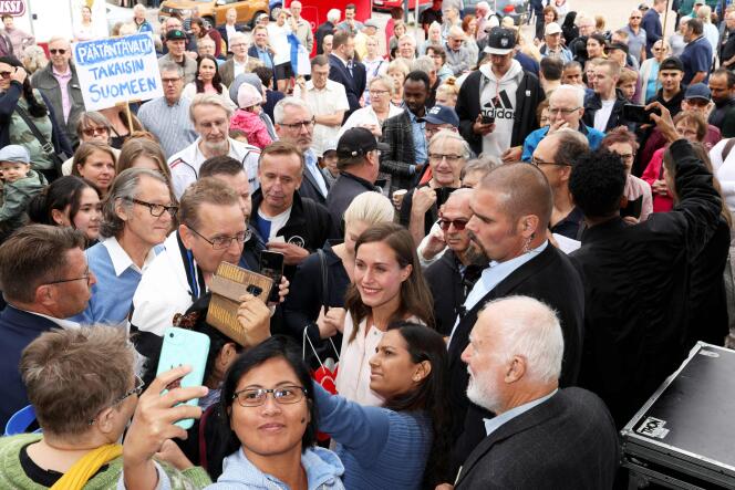 La première ministre finlandaise Sanna Marin pose pour un selfie avec des sympathisants lors d’une réunion de son parti à Hämeenlinna, le 25 août 2022. 