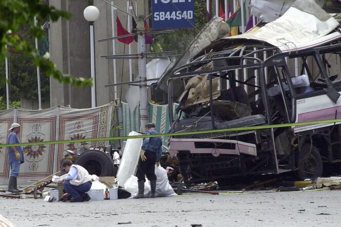 French investigators inspect the scene of the attack against the bus transporting French people, May 12, 2002 in Karachi, Pakistan. 