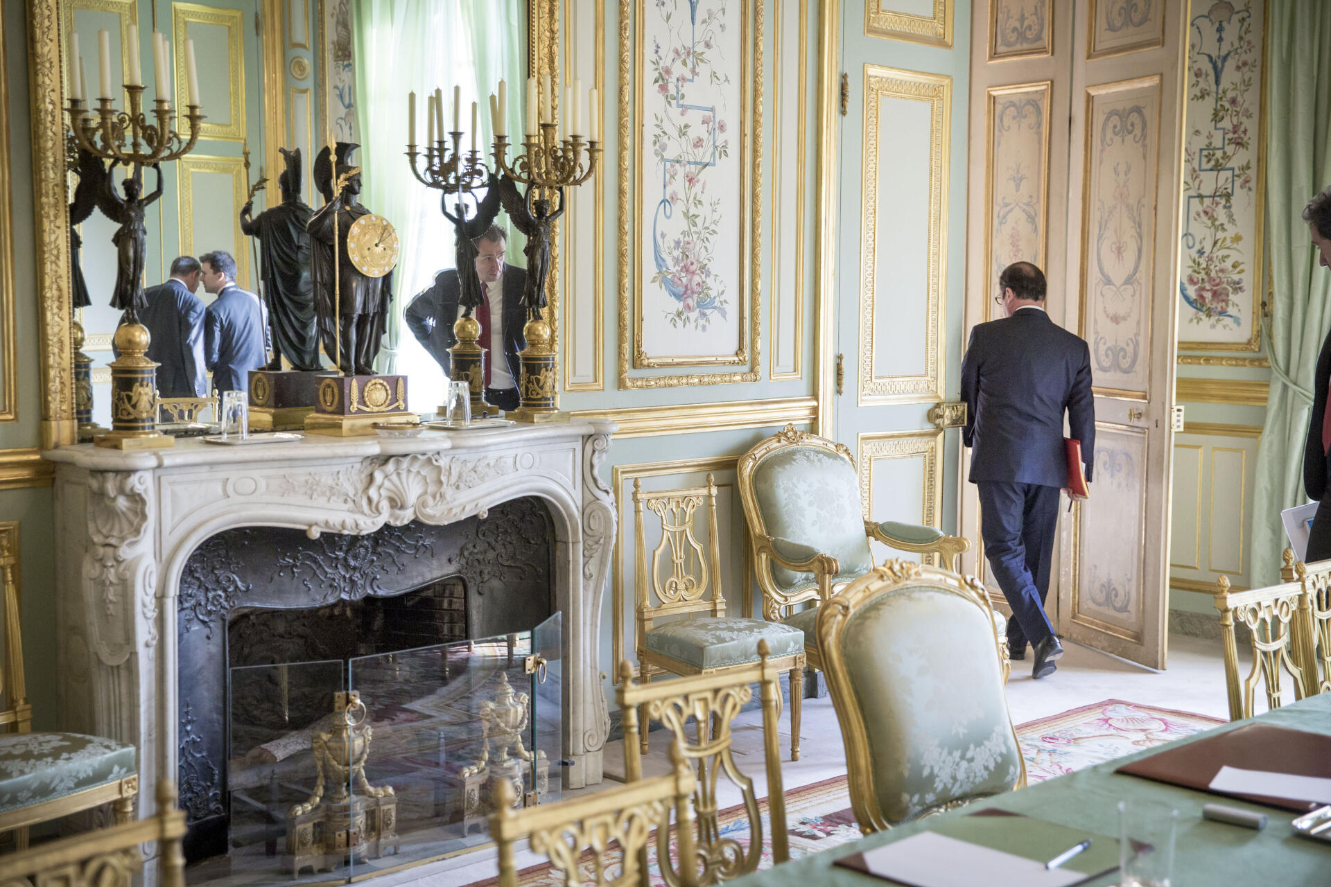 At the Palais de l'Elysée, in Paris, Thursday January 22, 2015. In the mirror, Gaspard Gantzer, communications adviser, speaks in the ear of Jean-Pierre Jouyet, secretary general of the Elysée.  Vincent Feltesse, adviser to the presidency, watches François Hollande, President of the Republic, come out of the green room.