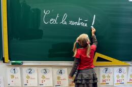 (FILES) In this file photograph taken on August 28, 2012, a young student writes on the blackboard "C'est la rentrée" (Its the Start of the school year) at the school Jules Ferry in Bethune, northern France, a few days ahead of the start of classes in France - known as "rentree des classes" in French.. Minister of Education Pap Ndiaye's promised on August 26, 2022 - that a competition would be held for contract teachers, those who make up for the lack of teachers - in "a context of unprecedented tension for the recruitment of teachers". Pupils are scheduled to return to schools across France on September 1, 2022. (Photo by Denis CHARLET / AFP)